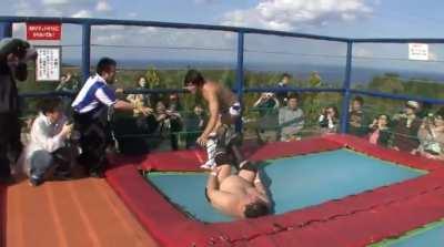 Kota Ibushi hits a Phoenix Splash inside a bouncy castle