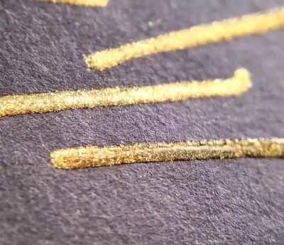 Macro video of gold ink as it dries