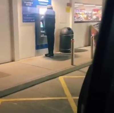 Patient people wait for mannequin at an ATM