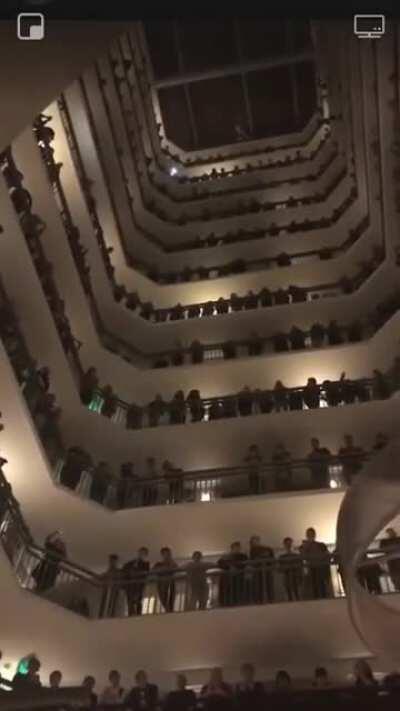 The Colorado All-State Mixed Choir singing from the balcony of the hotel they were staying at