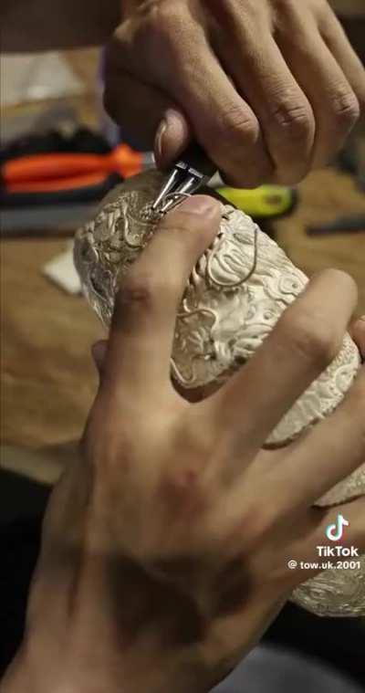 Artisan working on a metal bowl