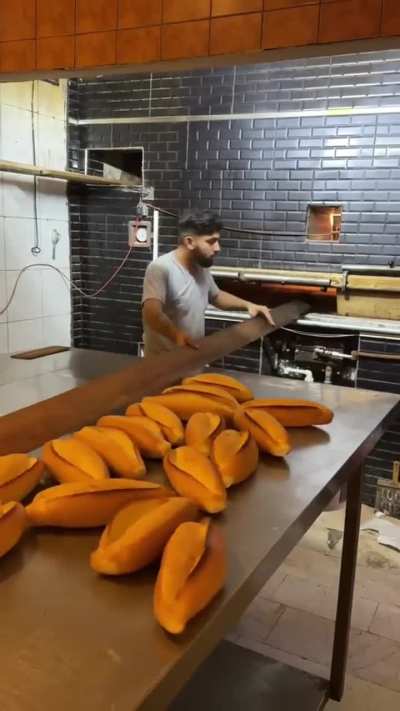 The lines of bread this man pulls out of the oven