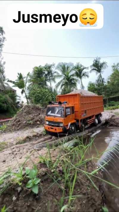 Truck crossing thru a wooden bridge