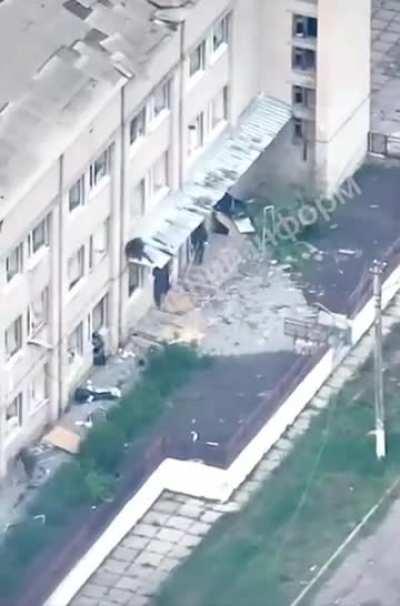 Russian soldier falls from 2nd story canopy of Vovchansk Central Hospital during assault. 