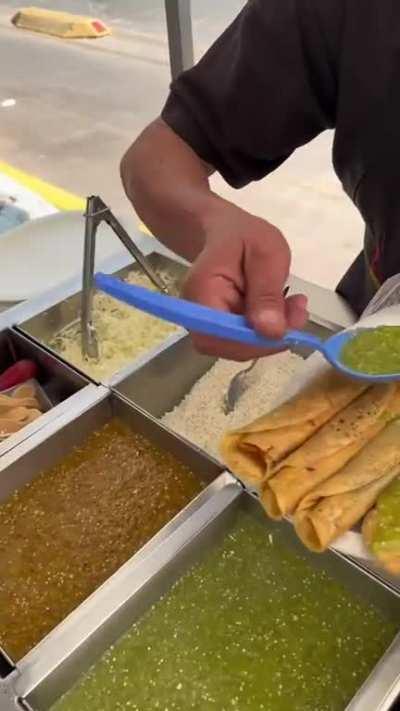 Spreading salsa on some flautas