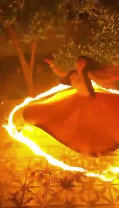 Women performs a Sama dance with a ring of fire around her dress