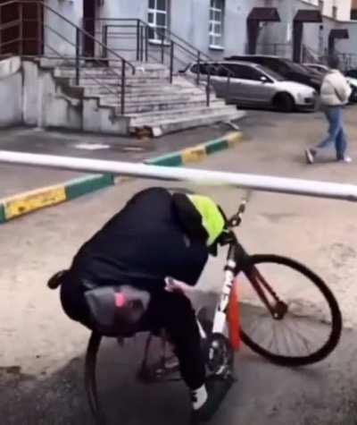 Man rides bicycle under gate