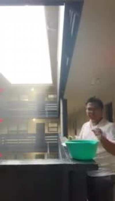 Man was doing dishes in the rain.