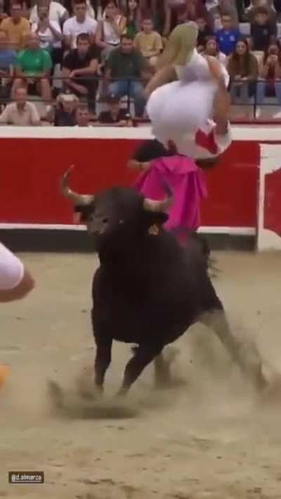 Man does a backflip over a live charging bull