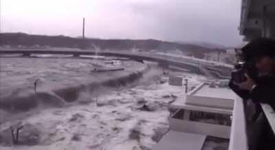 Tsunami security wall fails to stop water. Japan 2011