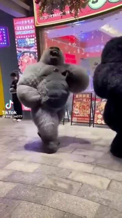 Overenthusiastic gorilla walking through a mall.