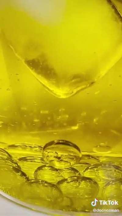 A cube of ice melting inside oil