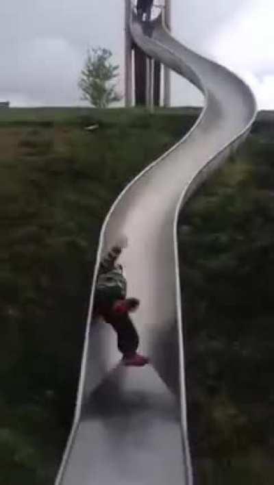 little kid goes on a very hard slide