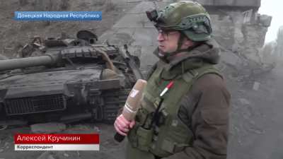 Russian news reporter shows a destroyed Russian T-80BV tank and calls it a Ukrainian T-72, at the railway bridge between Mykhailivka and Selydove