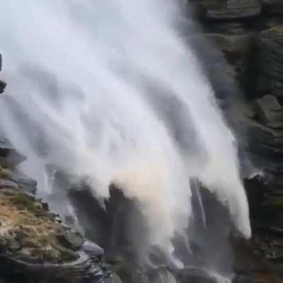 Heavy wind change the flow of this waterfalls direction in the opposite direction