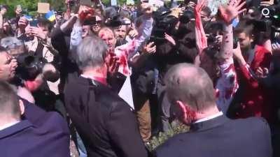 Russian ambassador doused with red paint by anti-war protesters as they chant 