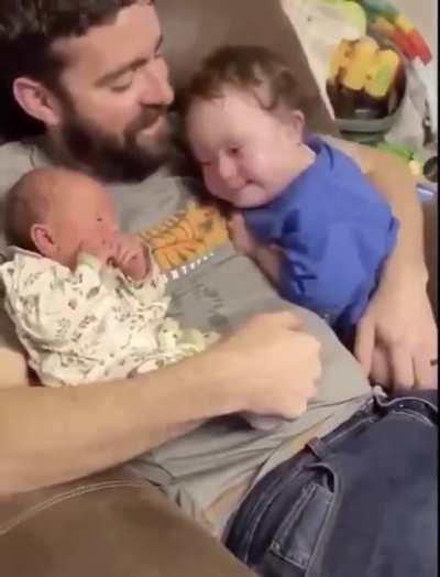 This sweet boy meeting his newborn sister for the first time