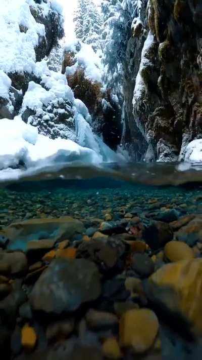 Snow falling on crystal clear Alaskan glacial melt water. Credit: Photographer John Derting.