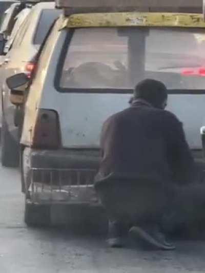 Man keeping a fire stoked in the back of his vehicle to replace heater.