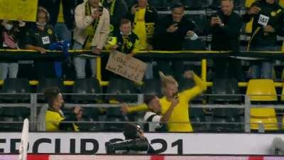 Kid holding a sign saying &quot;Hi Erling, can I have your shirt? It's my birthday tomorrow. Lots of thanks&quot; at the German Super Cup. Haaland goes into the stands to give the kid his shirt.