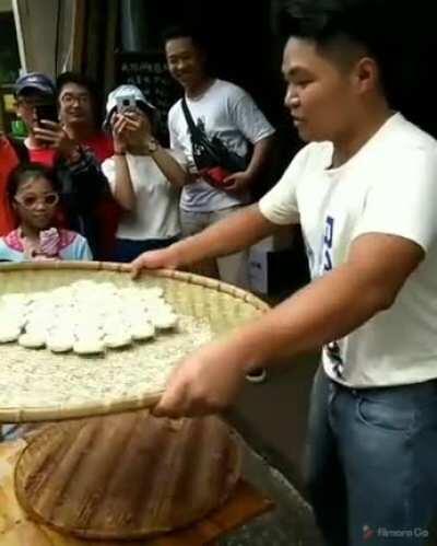 Street food vendor tosses rice cakes in perfect geometry