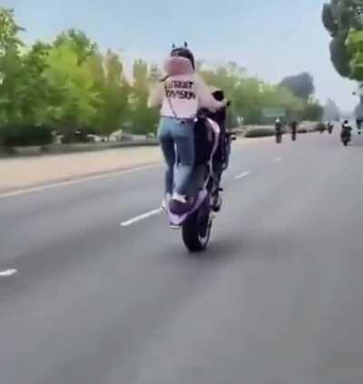 Woman on bike with a perfect wheelie