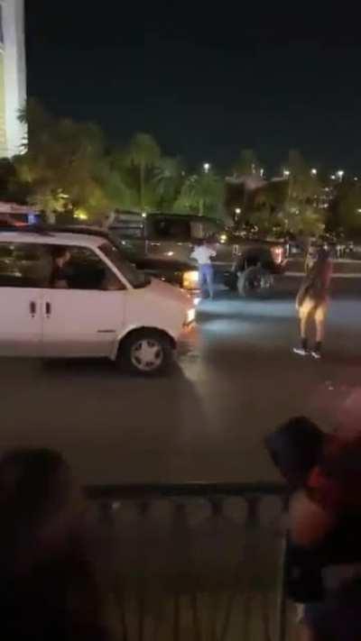 Anti-Trump protestor bangs on windows, doors of a pickup with Trump flag flying. Truck's driver runs out and shoves protestor