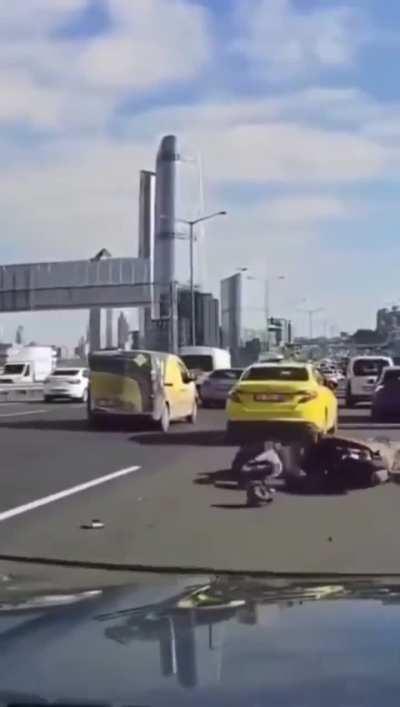 Main character motorcycle driver slaps other driver’s mirror and then crashes his motorcycle behind another vehicle.