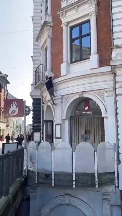 Man climbs a building with ease