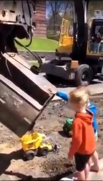 Bro construction worker fills kids' truck toy wit his big machine