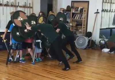 Students learning the strength of a proper shield wall