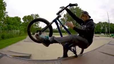 Guy solves Rubik's Cube while staying balanced on 1 Bike peg.