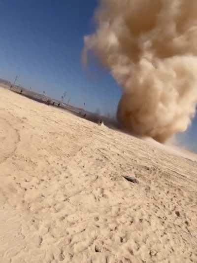 Men run toward massive dust devil