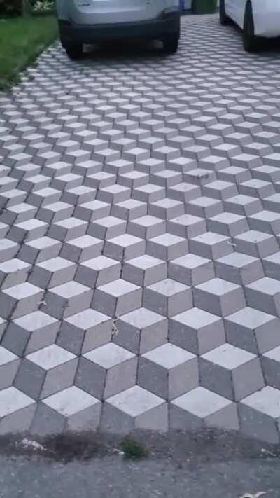 Tile pavers pattern on driveway creates optical illusion