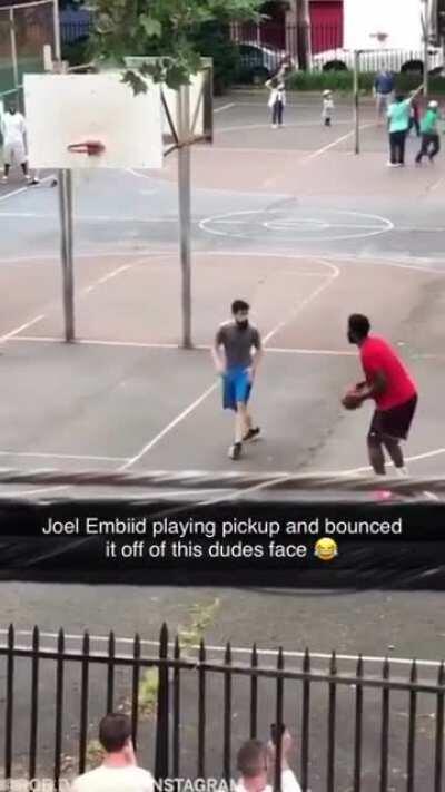 NBA Player Joel Embiid dunking on a random hooper