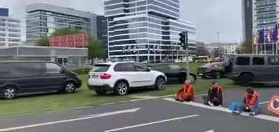 Climate activists block traffic lights so the traffic just drives over the verge and around them