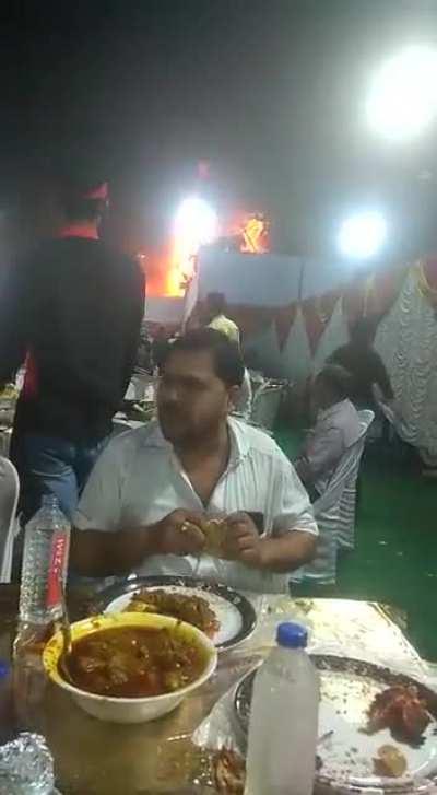 Indian wedding pandal catches fire. The guest is torn between checking it out and gobbling the delicious meal.