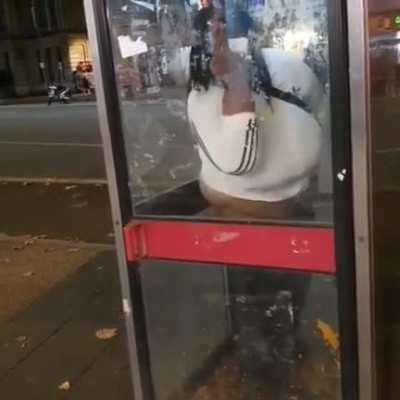 A woman taking a huge dump in a London phonebox