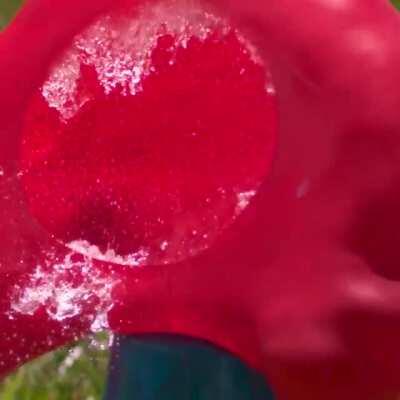 Water balloon getting obliterated by a baseball in slow mo