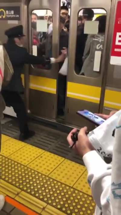 Elderly Japanese man intentionally delays an entire train schedule by sticking his hand out and blocking the train doors from closing