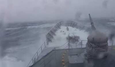 Military ship going through a monster wave