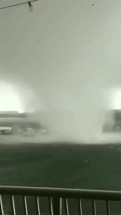 Guy stands on his balcony and gets insane footage of a tornado forming and heading into town. 