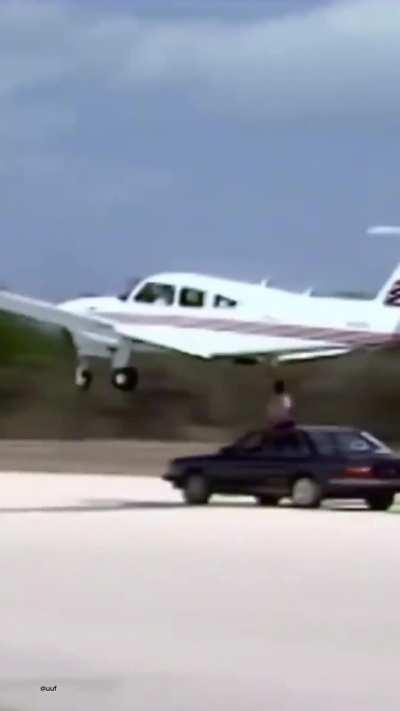 A man adjusts an airplane's landing gear from a moving car, 1985