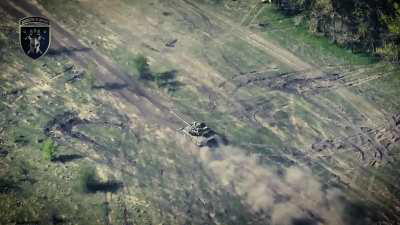 Ukrainian tank fires at Russian positions in Buhruvatka while a drone observes the hits on the target area, Kharkiv Oblast, July 2024