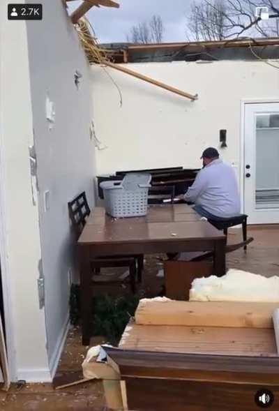 Kentucky man whose home was destroyed by a tornado sits in the remains of his living room and plays a Hymn on his piano.