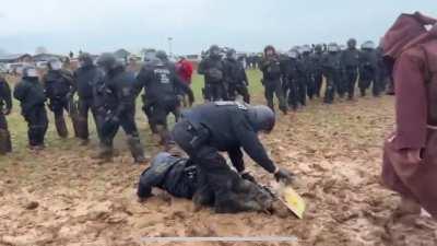 German cops get stuck in the mud while battling with climate protesters in heavy rain