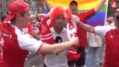 Swedish reporter tries to do his job between Danish supporters.