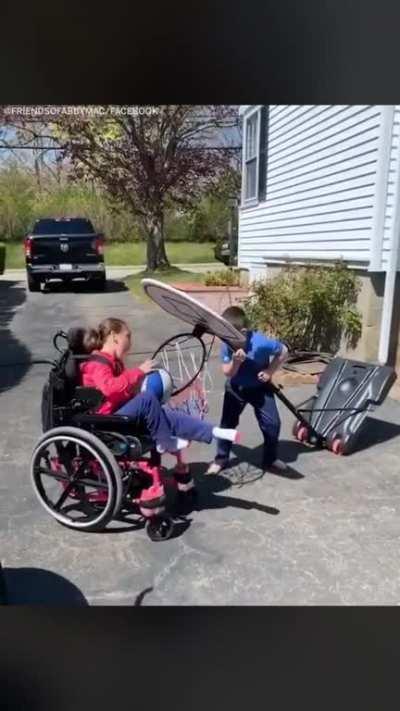 Brother helps sister make a shot