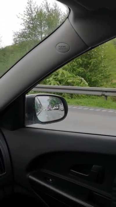 Motorist discipline in Denmark. Traffic parting to let emergency vehicles through on a two lane section of highway without hard shoulder.