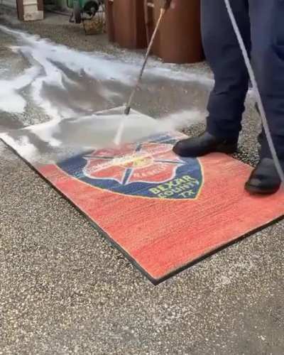 Power washing a carpet cleaning all the dirt away